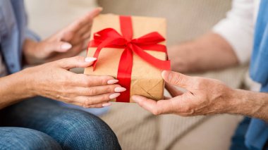Yaşlı adama Noel hediye kutusu veren yaşlı kadın