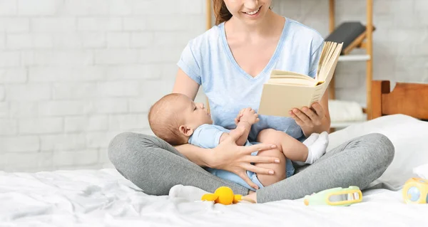 Щаслива мати читає книгу своєму малюкові вдома — стокове фото