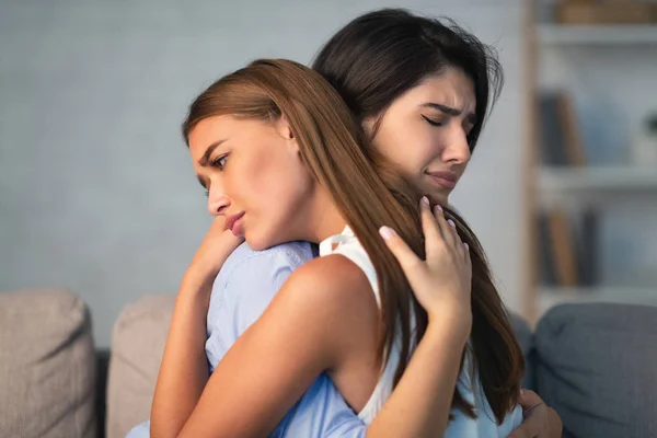 Compassionate Girl Supporting Desperate Friend Sitting On Sofa Indoor — Stock Photo, Image