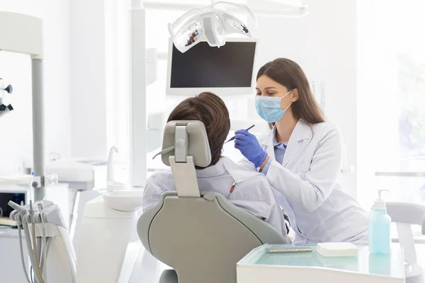 Jovem dentista fazendo tratamento para o paciente — Fotografia de Stock