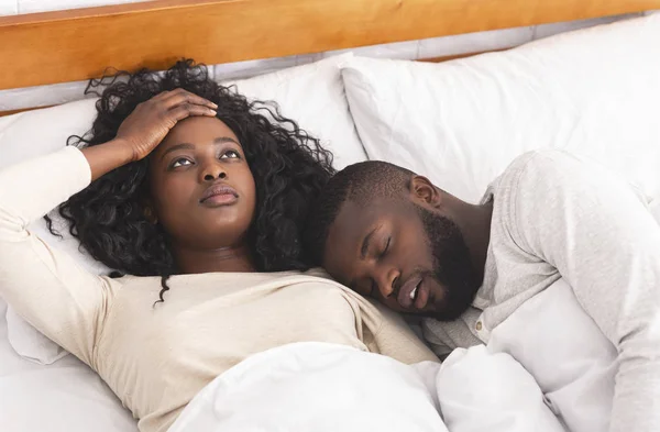 Frusztrált fiatal nő bosszantotta férje horkolás hangosan az ágyban — Stock Fotó