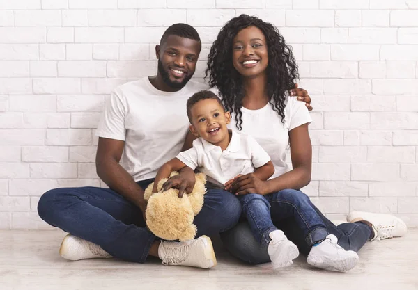 Jonge zwarte ouders en hun zoon zitten samen op de vloer — Stockfoto