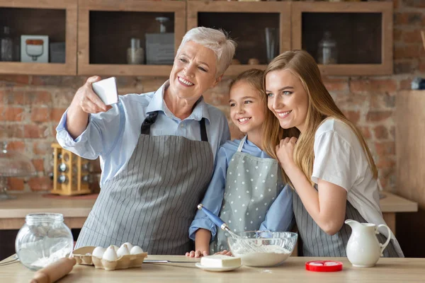 Familia femenina tomando selfie en el teléfono celular mientras cocinan juntos —  Fotos de Stock