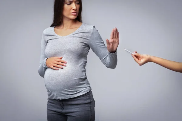 Беременная девушка отказывается принимать сигарет Жесты остановить, серый фон — стоковое фото