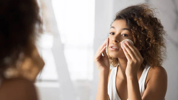 Mujer joven quitando maquillaje con almohadillas de algodón en el baño, Panorama —  Fotos de Stock