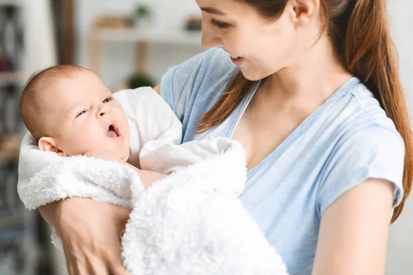 Söt nyfödda barnet sött gäspningar på mödrar händer — Stockfoto