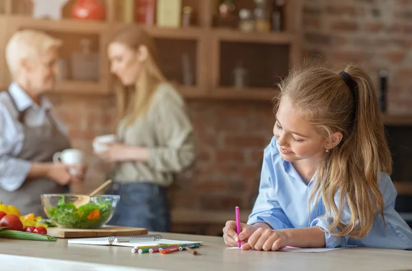 Ragazza che dipinge in cucina mentre aiuta mamma e nonna — Foto Stock