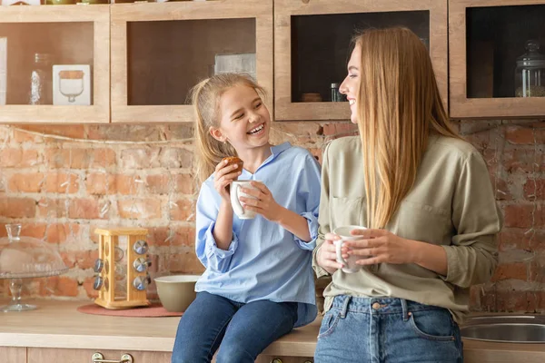 Feliz madre e hija bebiendo té en la cocina —  Fotos de Stock