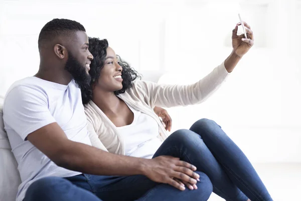 Negro millennial pareja tomando selfie en smartphone en casa —  Fotos de Stock