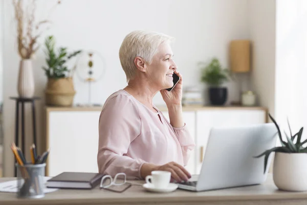 Opgewonden Senior vrouw die telefonisch met de klant praat — Stockfoto