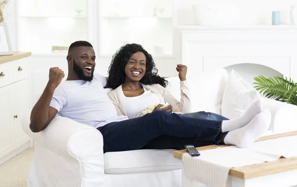 Negro millennial pareja viendo deportes en televisión y animando —  Fotos de Stock