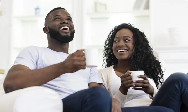 Чёрная пара наслаждается временем вместе, пьет кофе дома — стоковое фото