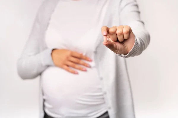 Gadis hamil Menampilkan Pill Menyentuh Perut Atas Latar Belakang Putih, Dipotong — Stok Foto