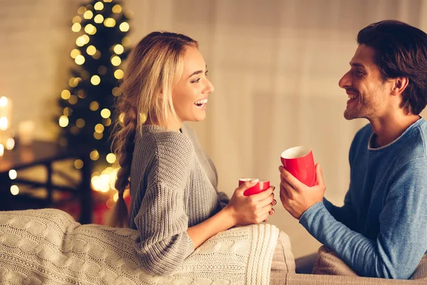 Heiligabend. glückliches Paar trinkt Tee im gemütlichen Zimmer — Stockfoto