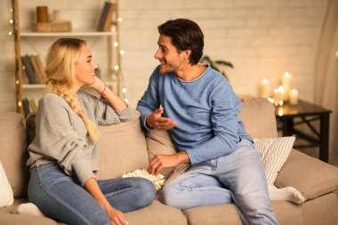 Sevimli çift konuşma ve rahat odada patlamış mısır yeme