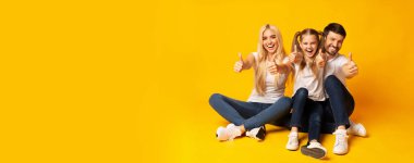 Heyecanlı Aile Gesturing Thumbs Up Katta Oturan, Studio Shot