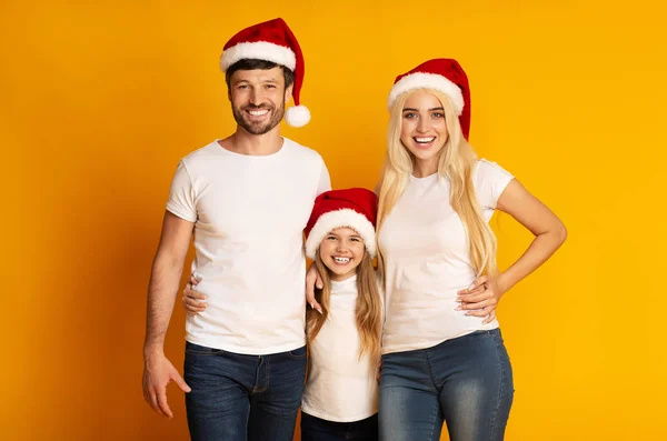Famiglia in Santa Cappelli Abbracci in piedi su sfondo giallo — Foto Stock