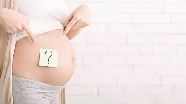 Беременная женщина брюхо с вопросительным знаком, панорама — стоковое фото