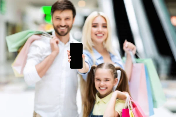 Família mostrando tela de celular vazia em pé no shopping, Mockup — Fotografia de Stock