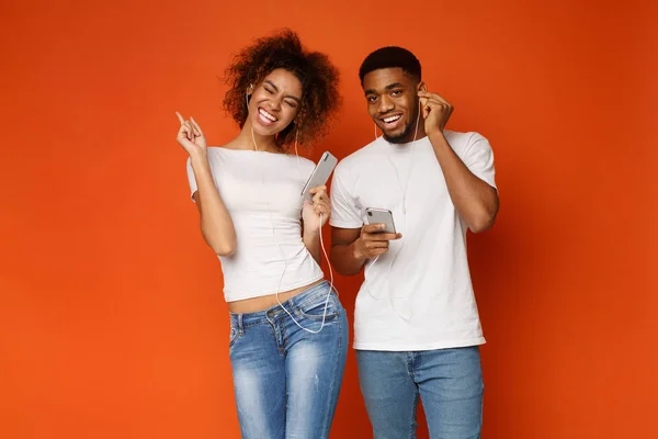 Milenial positif afro pria dan wanita di earphone mendengarkan musik — Stok Foto
