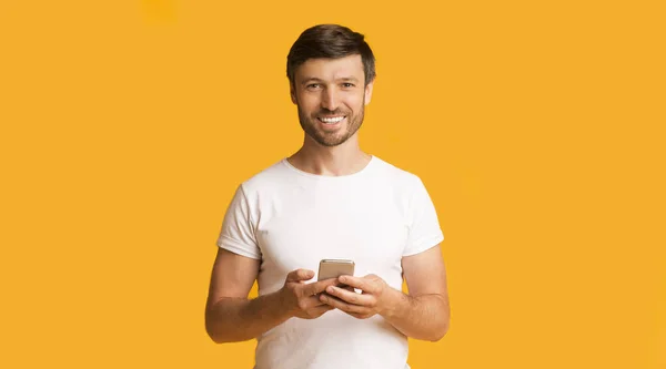 Glimlachende man met smartphone, Studio Shot, Panorama — Stockfoto
