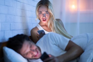 Kıskanç Girlfriend Catching Erkek Arkadaşı Yatakta Yatan Kadınlarla Mesajlaşma