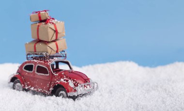 Red toy car with Christmas presents on background