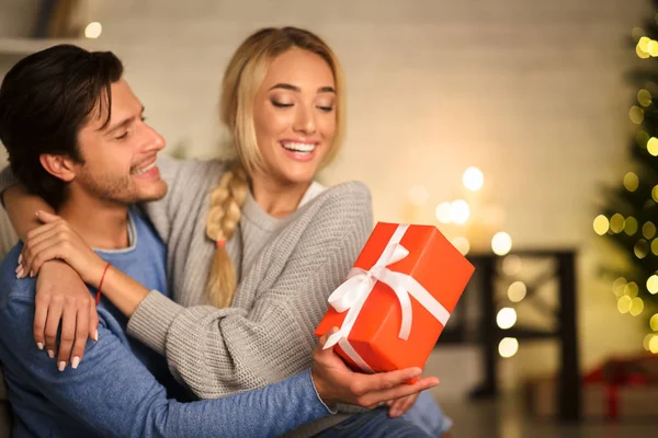 Par firar nyår, man ger present till hustru — Stockfoto