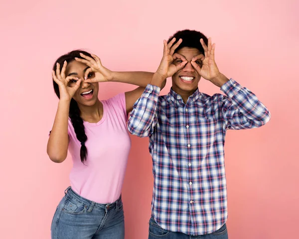Överlycklig par gör roliga glasögon, hålla fingrarna nära ögonen — Stockfoto
