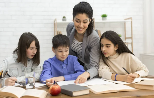 Onderwijsconcept. Gelukkig leraar het helpen van kinderen doen test — Stockfoto