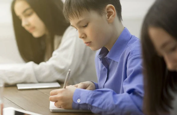 Leerlingen die een tentamen schrijven in de klas — Stockfoto