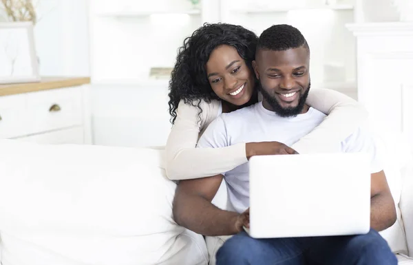 Gelukkig Afrikaanse Amerikaanse echtpaar met behulp van laptop samen thuis — Stockfoto