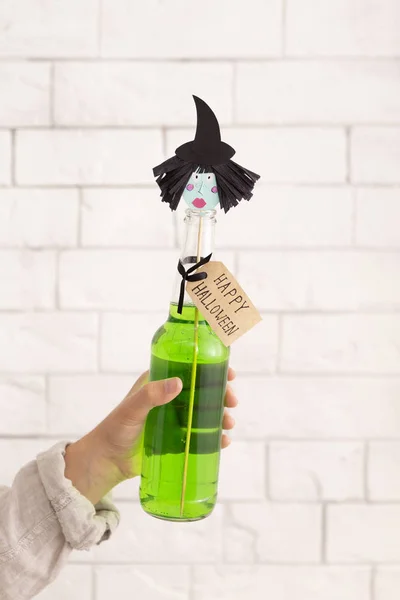 Bebida de festa verde com papel bruxas cabeça sobre tijolos parede — Fotografia de Stock