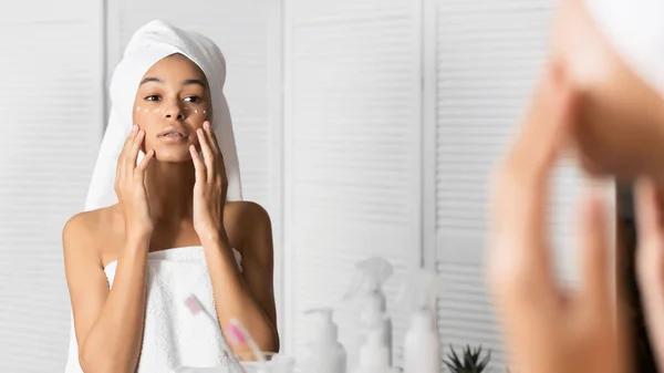 Meisje met handdoek op hoofdtoepassing Eye Cream in de badkamer — Stockfoto