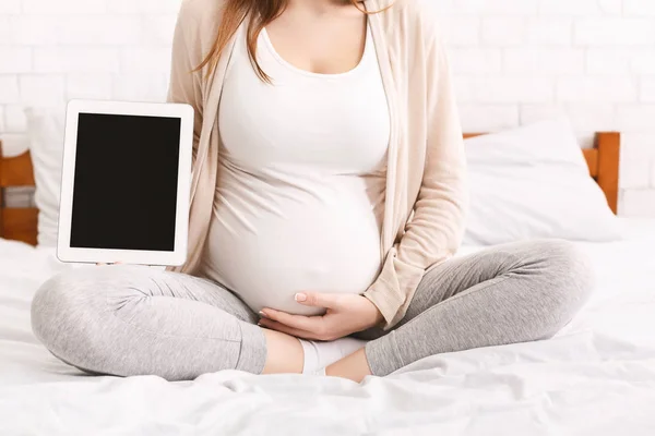 Schwangere hält digitales Tablet mit leerem Bildschirm — Stockfoto