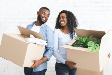 Genç çift ellerinde karton kutular, birbirlerine gülümsüyorlar.