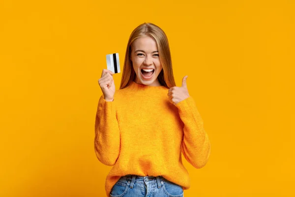 Безтурботний молода дівчина показує великий палець вгору, схвильований майбутніми покупками — стокове фото