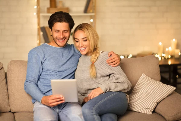 Pareja cariñosa usando tableta, tener videollamada en la noche acogedora —  Fotos de Stock