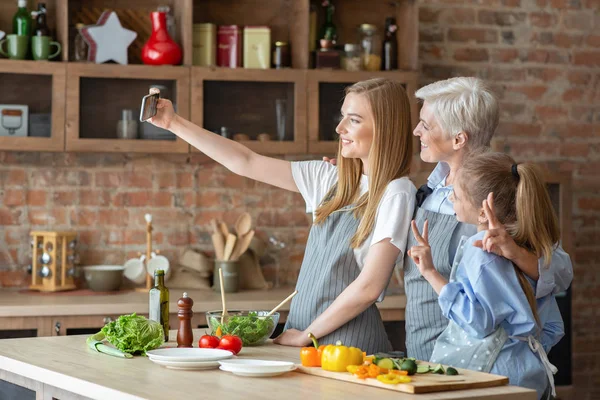 Hija, madre y abuela tomando selfie mientras hacen la cena juntos — Foto de Stock