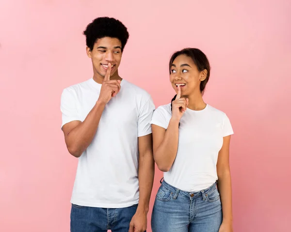 Amazed teen couple make silence sign, keep forefingers on lips — Stockfoto