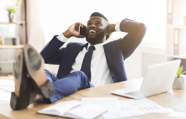 Alegre gerente negro hablando por teléfono mientras tiene descanso —  Fotos de Stock