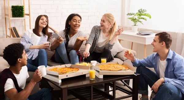 Thuis feestje. Tieners die pizza eten en kletsen — Stockfoto