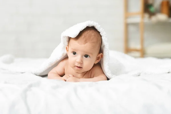Urocze noworodek leżące na łóżku pod białym kocem — Zdjęcie stockowe