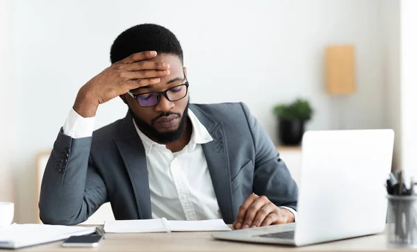Fáradt afrikai üzletember ül a munkahelyen frusztrált üzleti kudarc — Stock Fotó