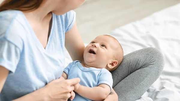 Adorable baby boy looking at mom, lying on her laps — Stock Photo, Image