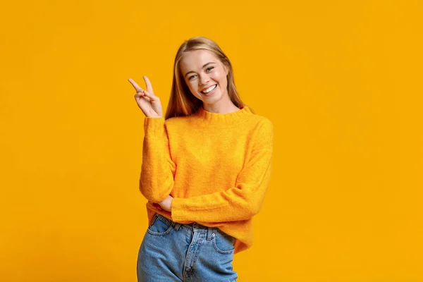 Cherful tiener meisje tonen v-teken poseren naar camera — Stockfoto