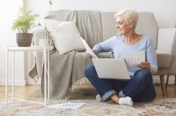 Starší finanční poradce sedí na patře s notebookem doma — Stock fotografie