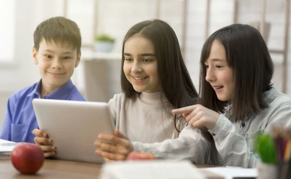 Leerlingen kijken naar grappige content op tablet in de klas — Stockfoto