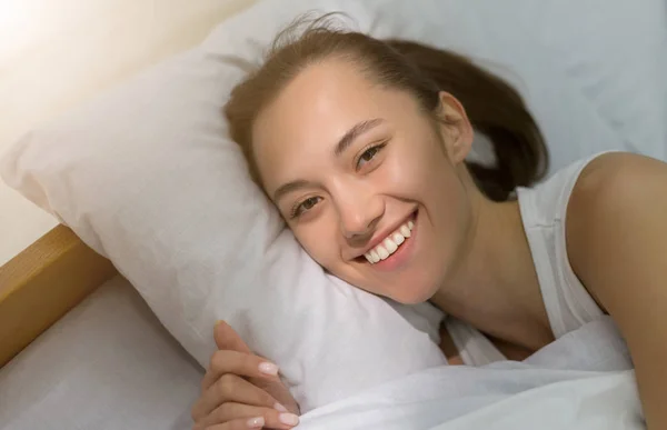 Mañana soleada. Mujer feliz despertando, acostada en la cama — Foto de Stock