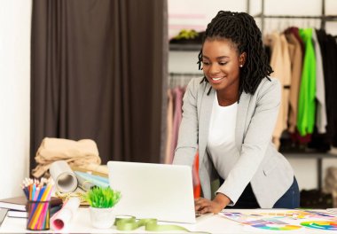 Showroom 'da Laptop kullanan Afrikalı Amerikalı Elbise Satıcısı
